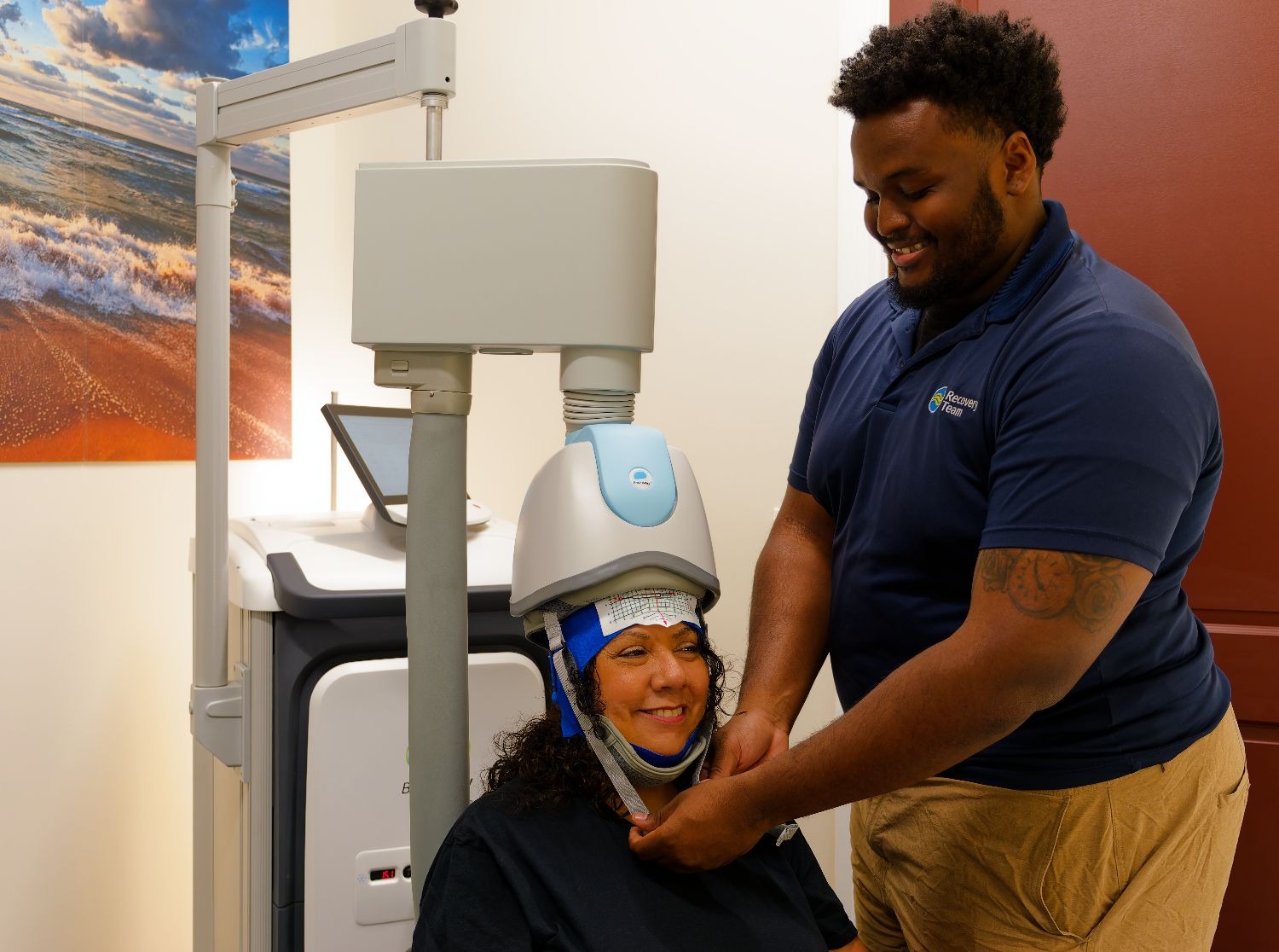 Technician adjusts TMS headgear on a patient during treatment.