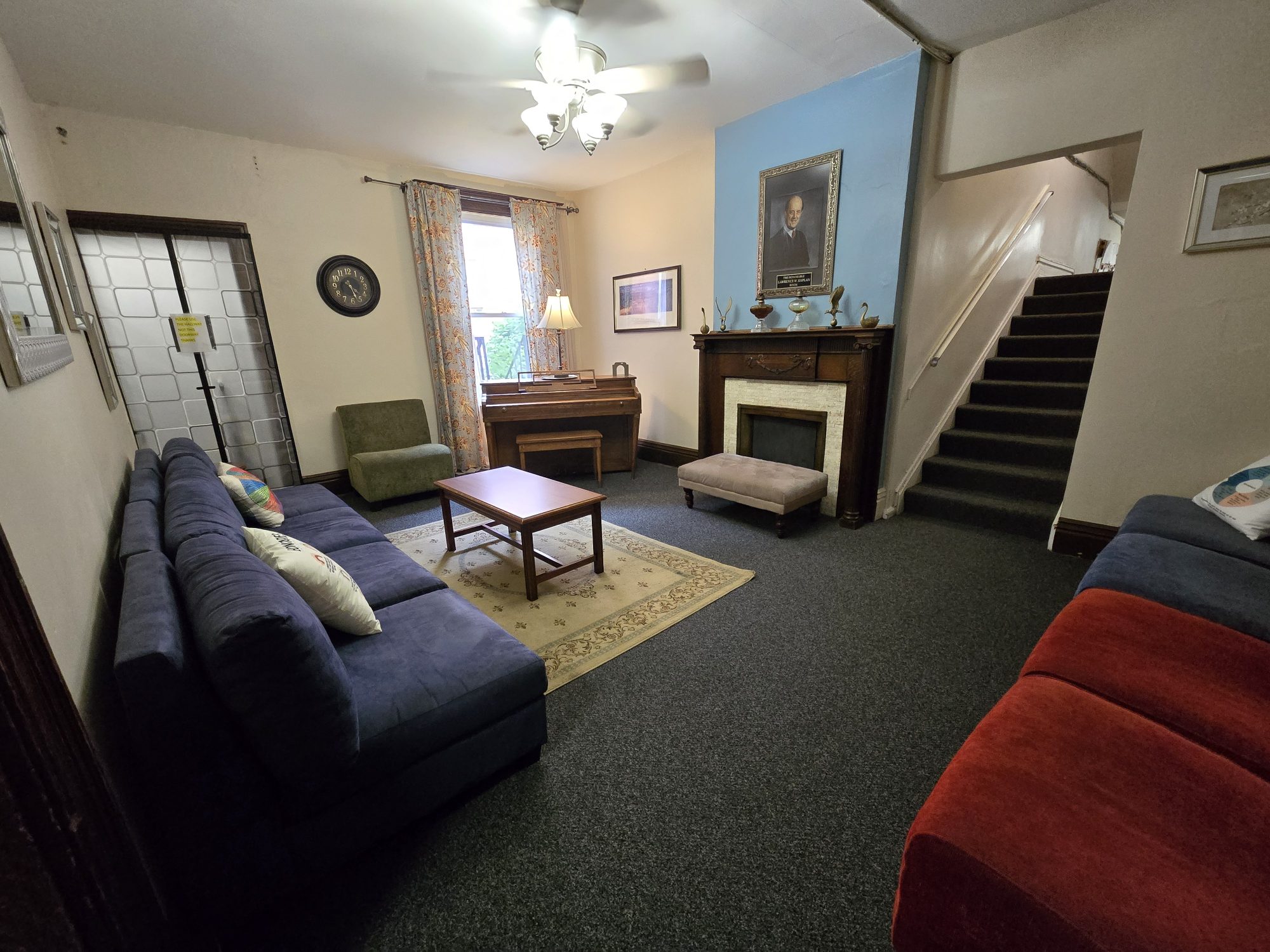 Lounge with sofas, piano, and fireplace.
