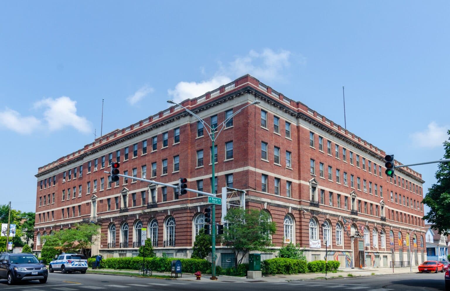 Historic four-story red brick building on a busy city corner
