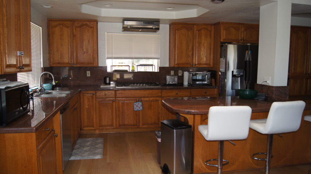 Spacious kitchen with wooden cabinets and bar stools