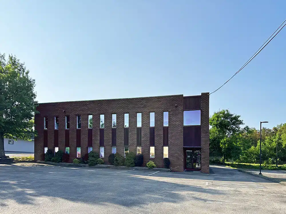 Brick clinic building with parking lot and trees outside
