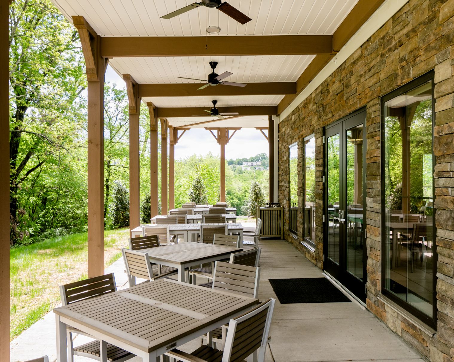 Covered patio with tables overlooking wooded scenery