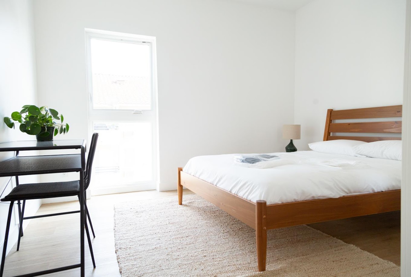  Sunlit bedroom with wood bed and workspace