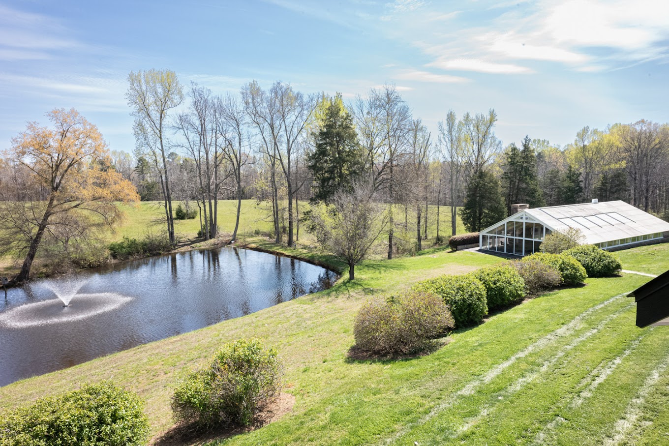 Facility exterior with pond and greenery.