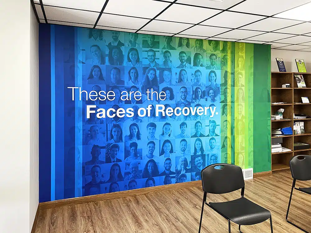 Colorful Faces of Recovery mural with seating area