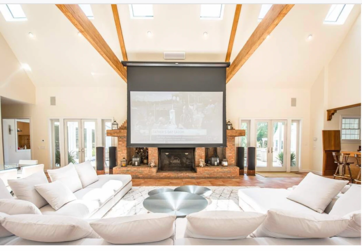 Lounge with large screen and white sectional seating