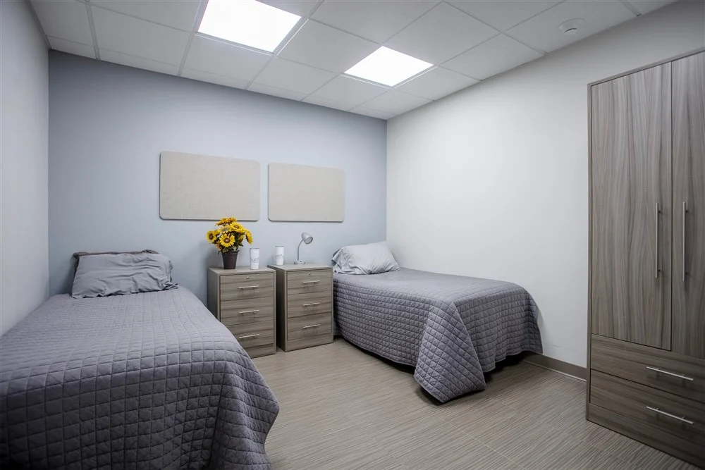 Shared bedroom with two beds and storage furniture