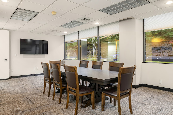 Conference room with a table, chairs and a TV.