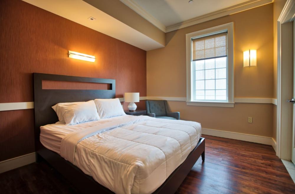 Cozy private bedroom with queen bed and warm lighting