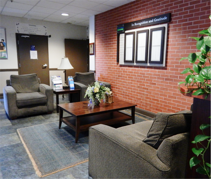 Comfortable lobby with armchairs, coffee table, and wall display