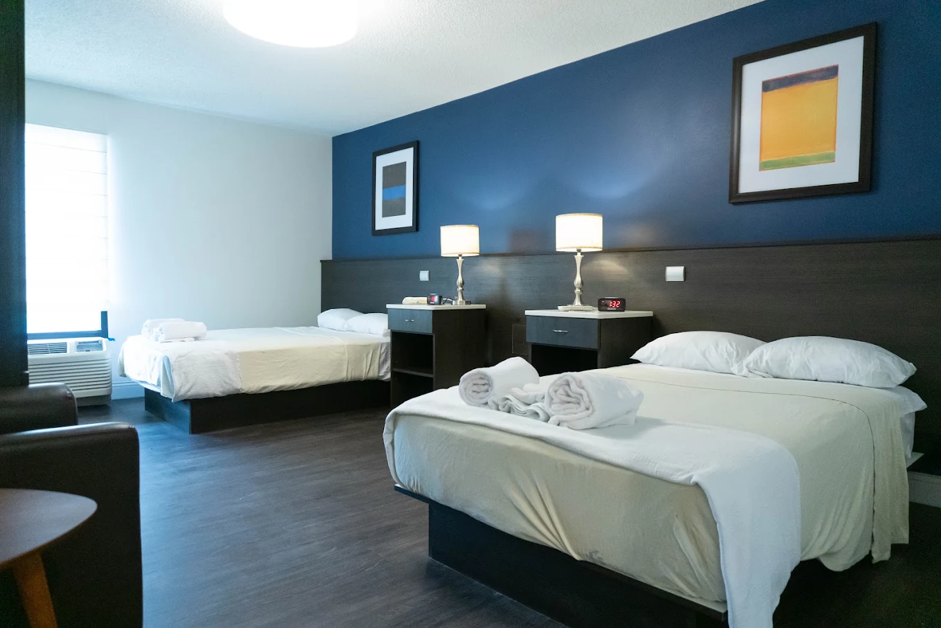 Shared bedroom with two beds, lamps, and blue accent wall