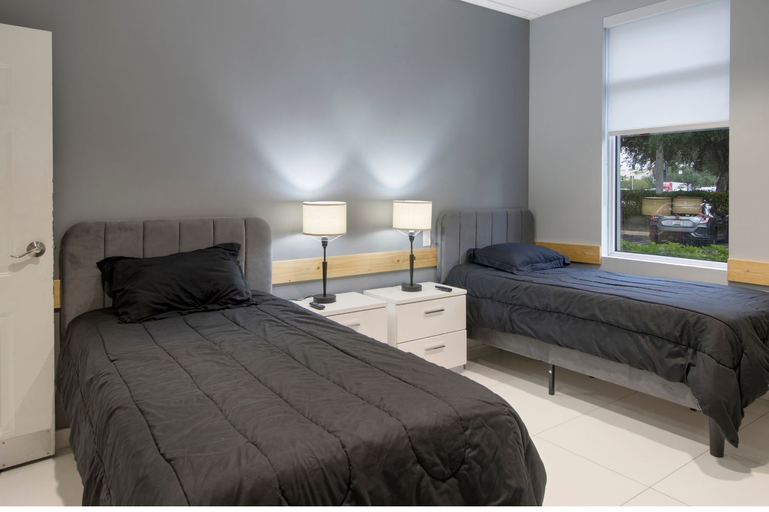 Room with two twin beds, lamps, and nightstand