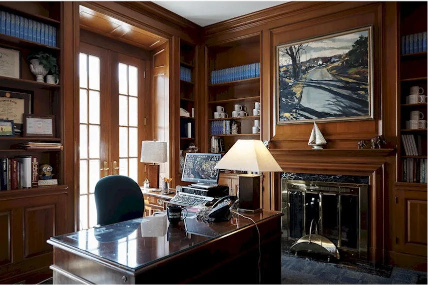 Wood-paneled administrative office with desk and fireplace.