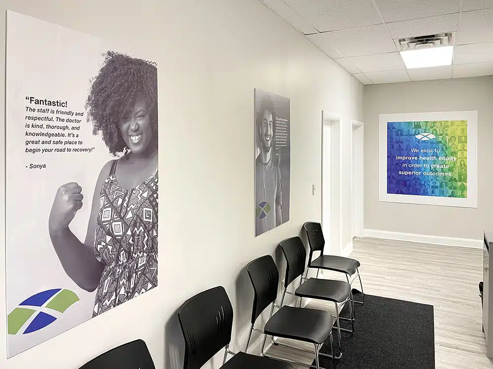 Chairs along hallway with large patient testimonial poster
