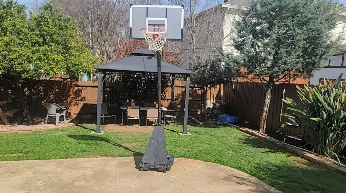 Outdoor basketball hoop in grassy rehab facility yard
