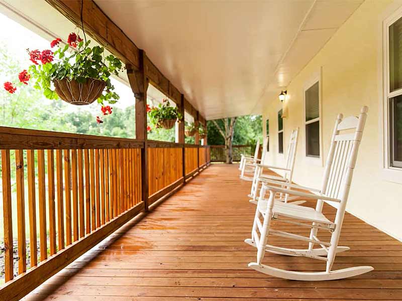 Wooden porch with rocking chairs and hanging flowers