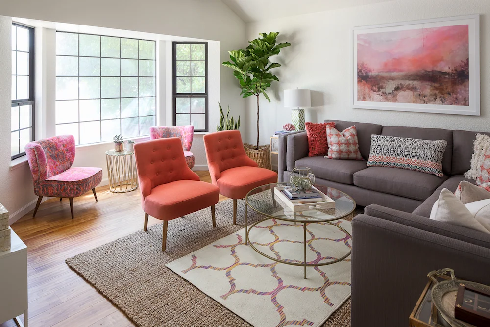 Living room with coral chairs and large sunny windows