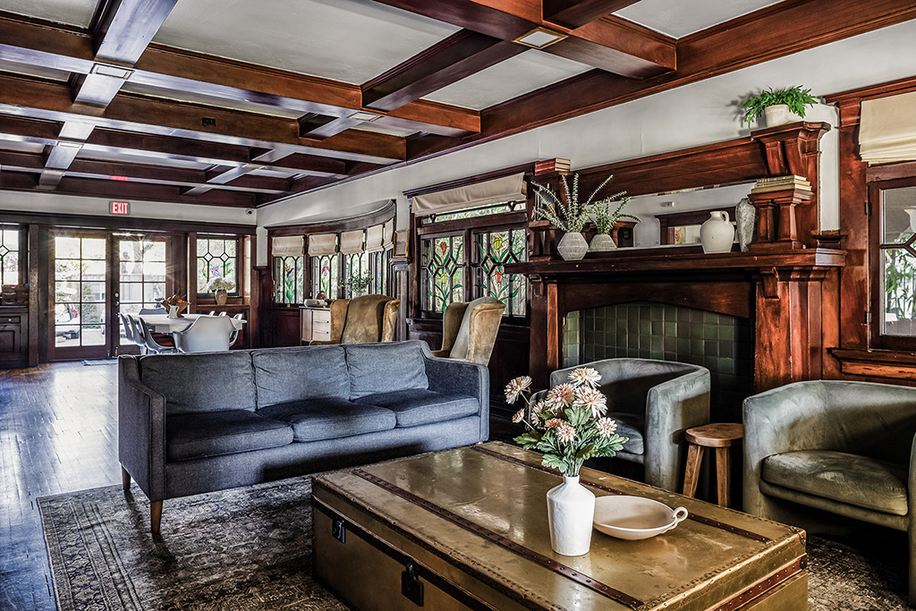 Cozy living room with gray sofa, fireplace, and wooden ceiling beams