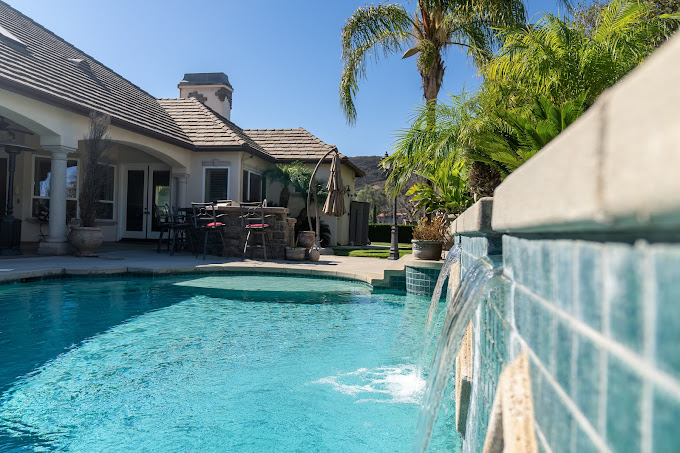 Pool with waterfall features and shaded patio area