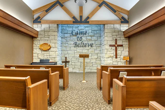 Chapel with pew seating and stone wall