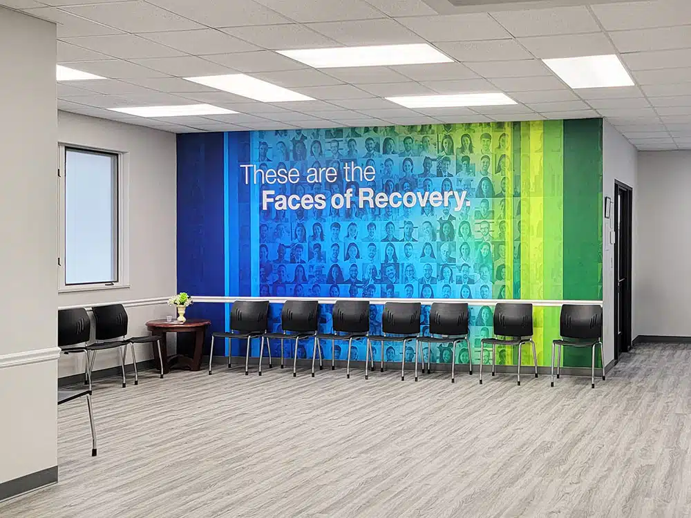 Waiting room with chairs and Faces of Recovery wall mural
