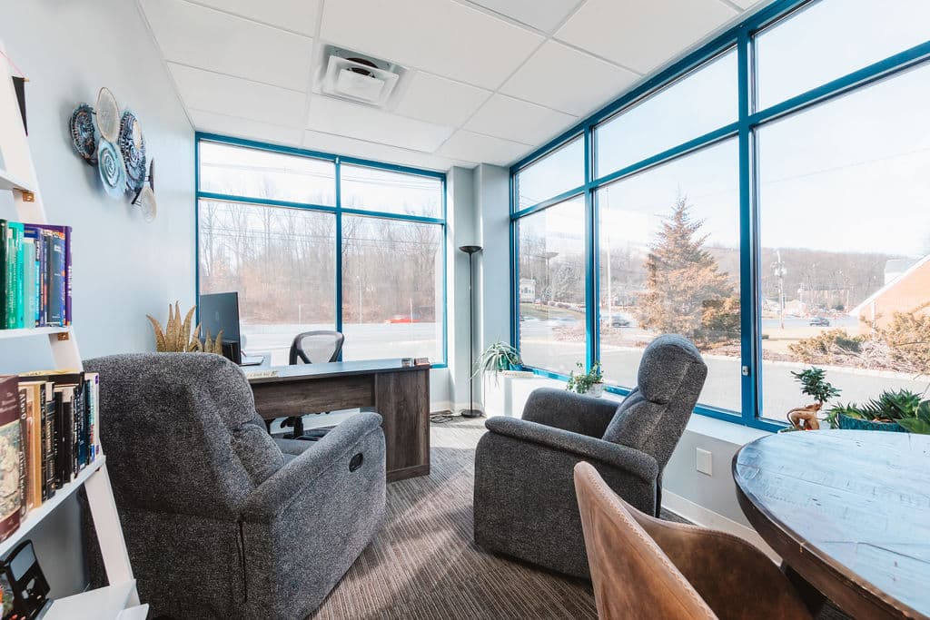Cozy private client room with two recliners and large windows
