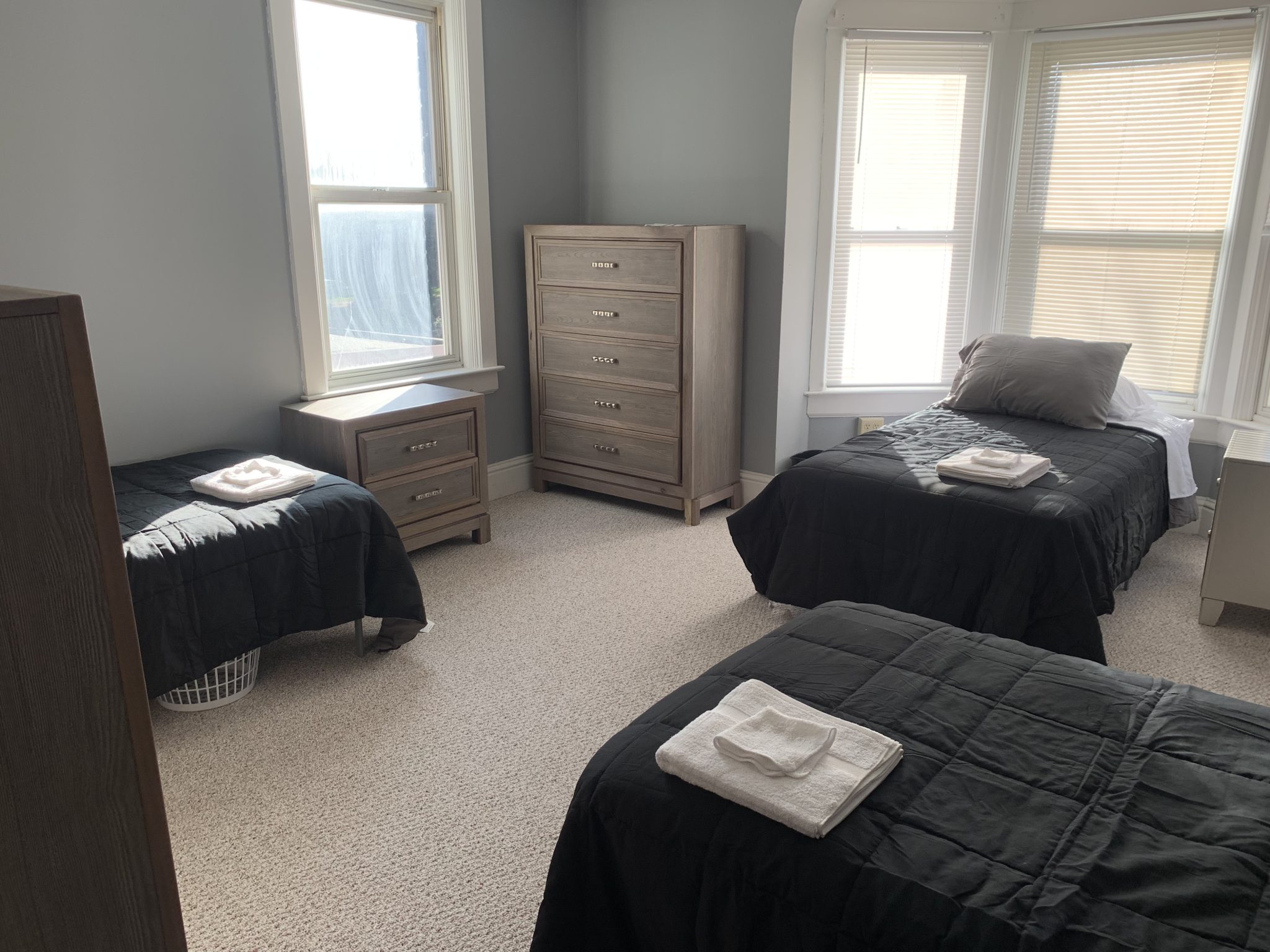 Bright room with three twin beds and modern wood furniture