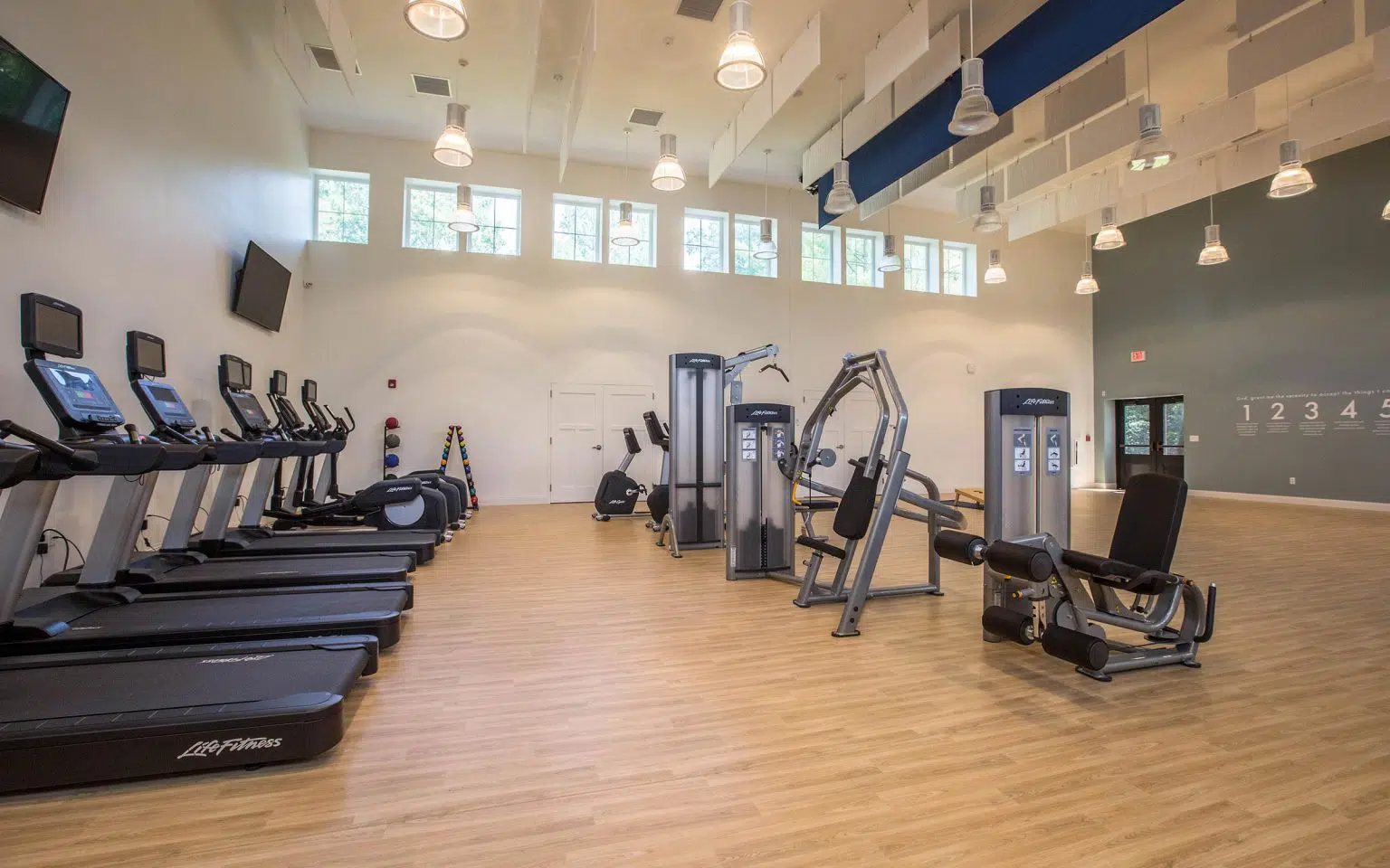 Fitness center with treadmills, weight machines, and bright lighting