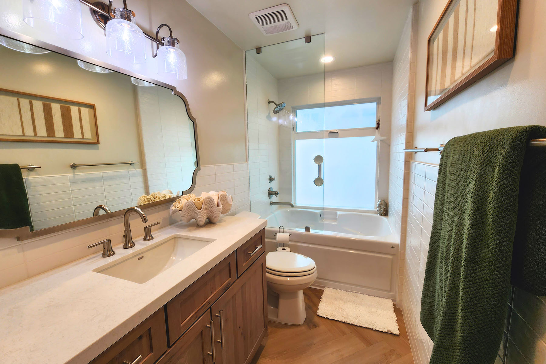 Bathroom with wood vanity and glass tub enclosure
