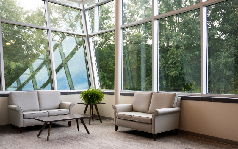 Lounge seating beside floor-to-ceiling windows