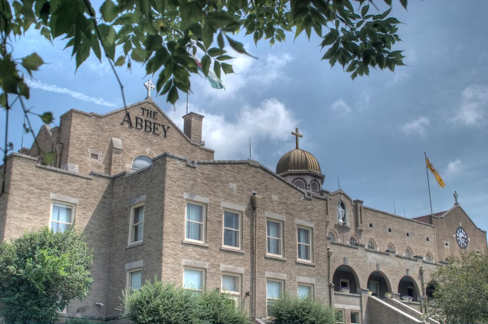 Brick rehab building with cross-topped dome and cloudy sky