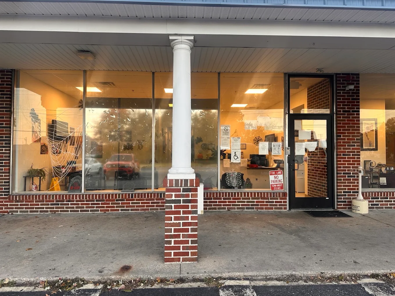 Glass entrance and windows along a covered brick walkway