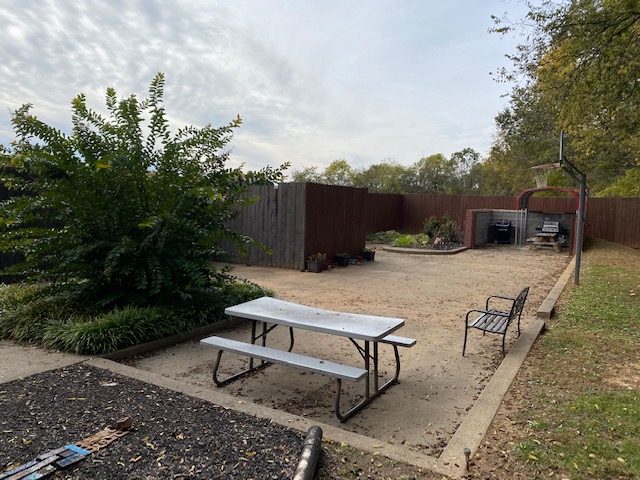 Outdoor courtyard with picnic table and basketball hoop