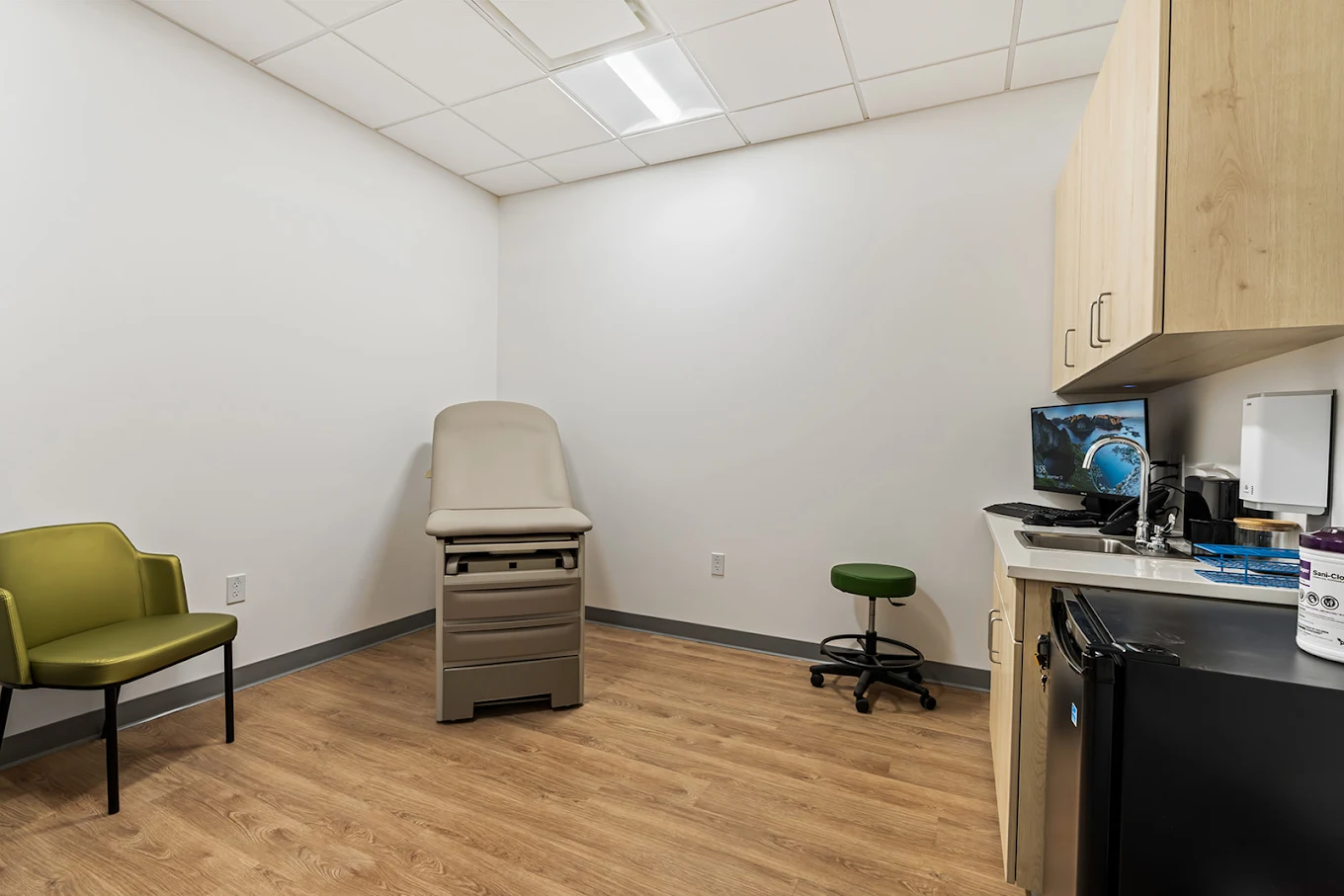 Medical exam room with exam table and cabinetry