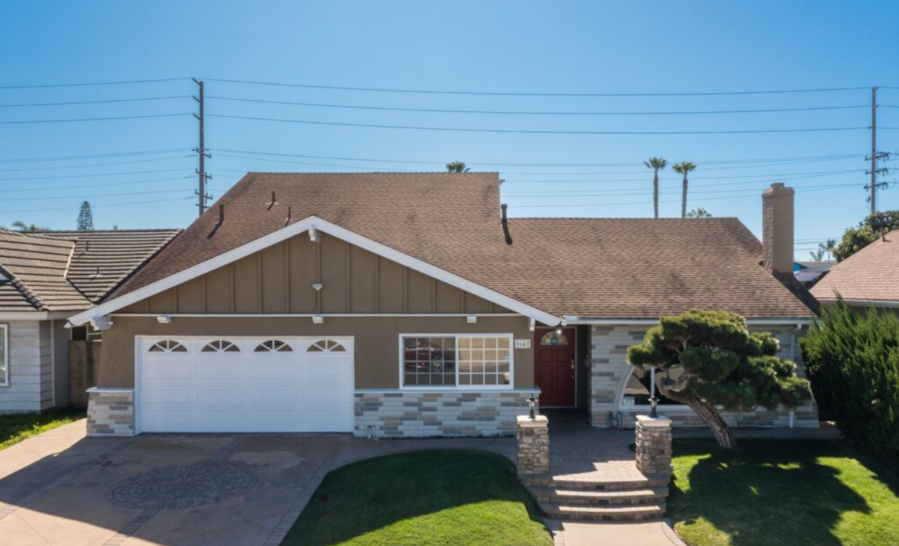 Front view of house with garage, lawn, and red door