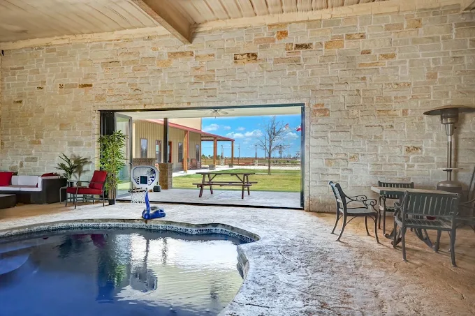Indoor pool area with seating and outdoor views