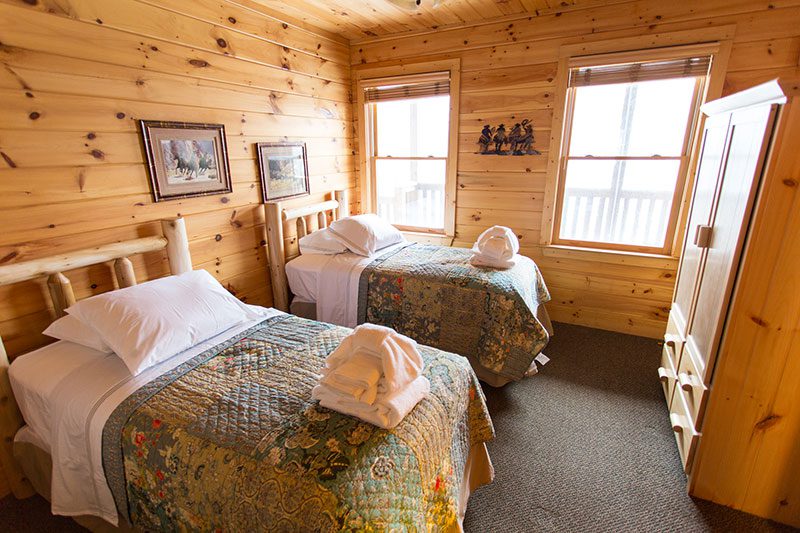 Shared bedroom with twin beds and rustic wood interior