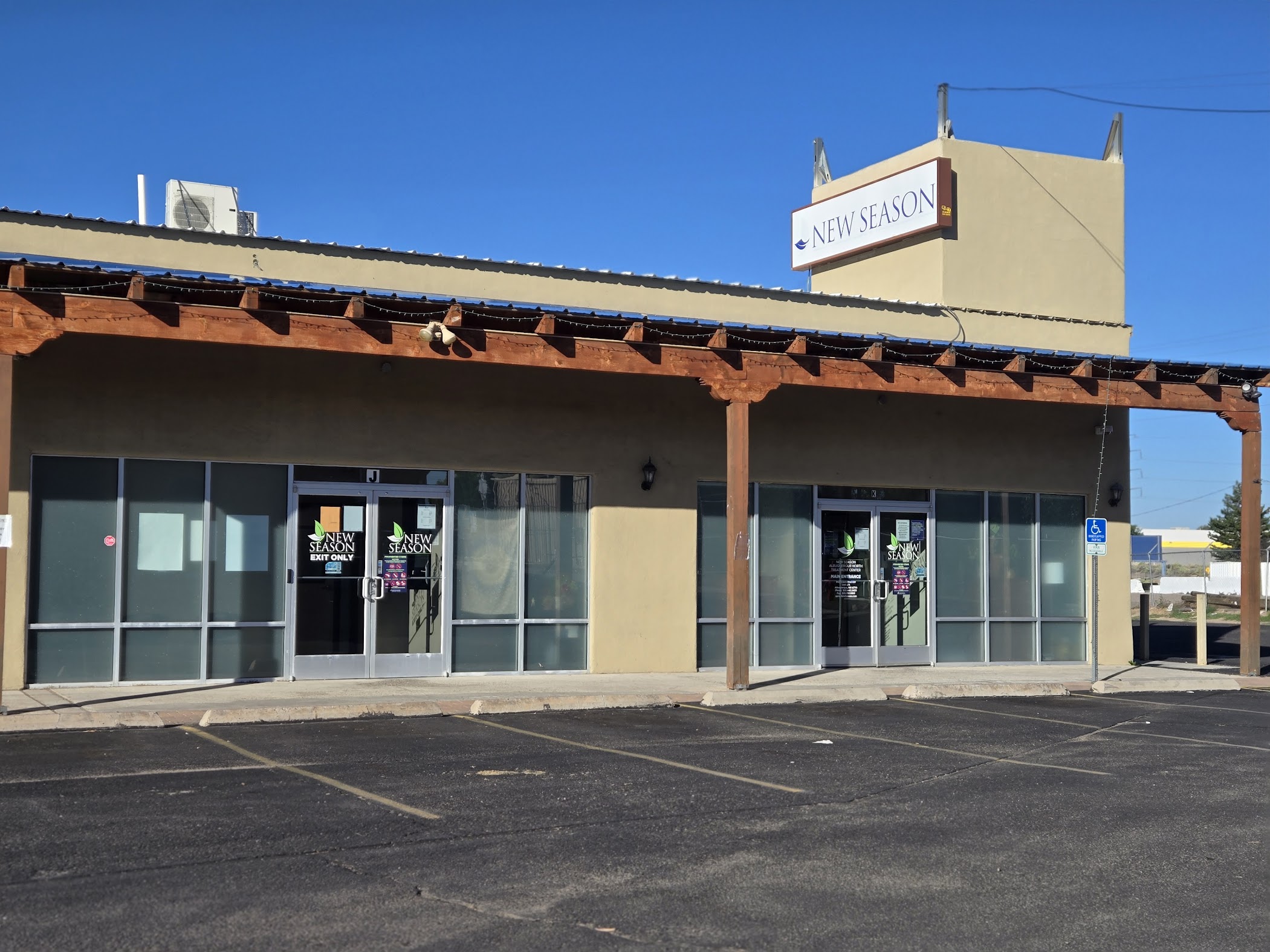 Exterior view of clinic with glass doors and parking lot