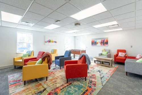 Colorful chairs and foosball table in rec room