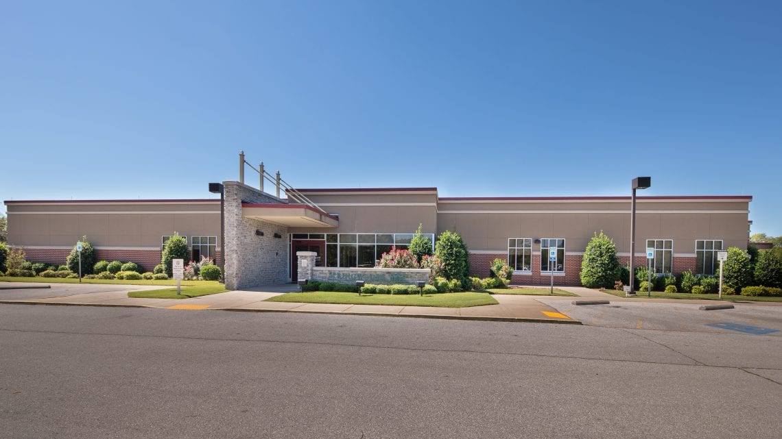 Main entrance with covered drop-off and landscaping