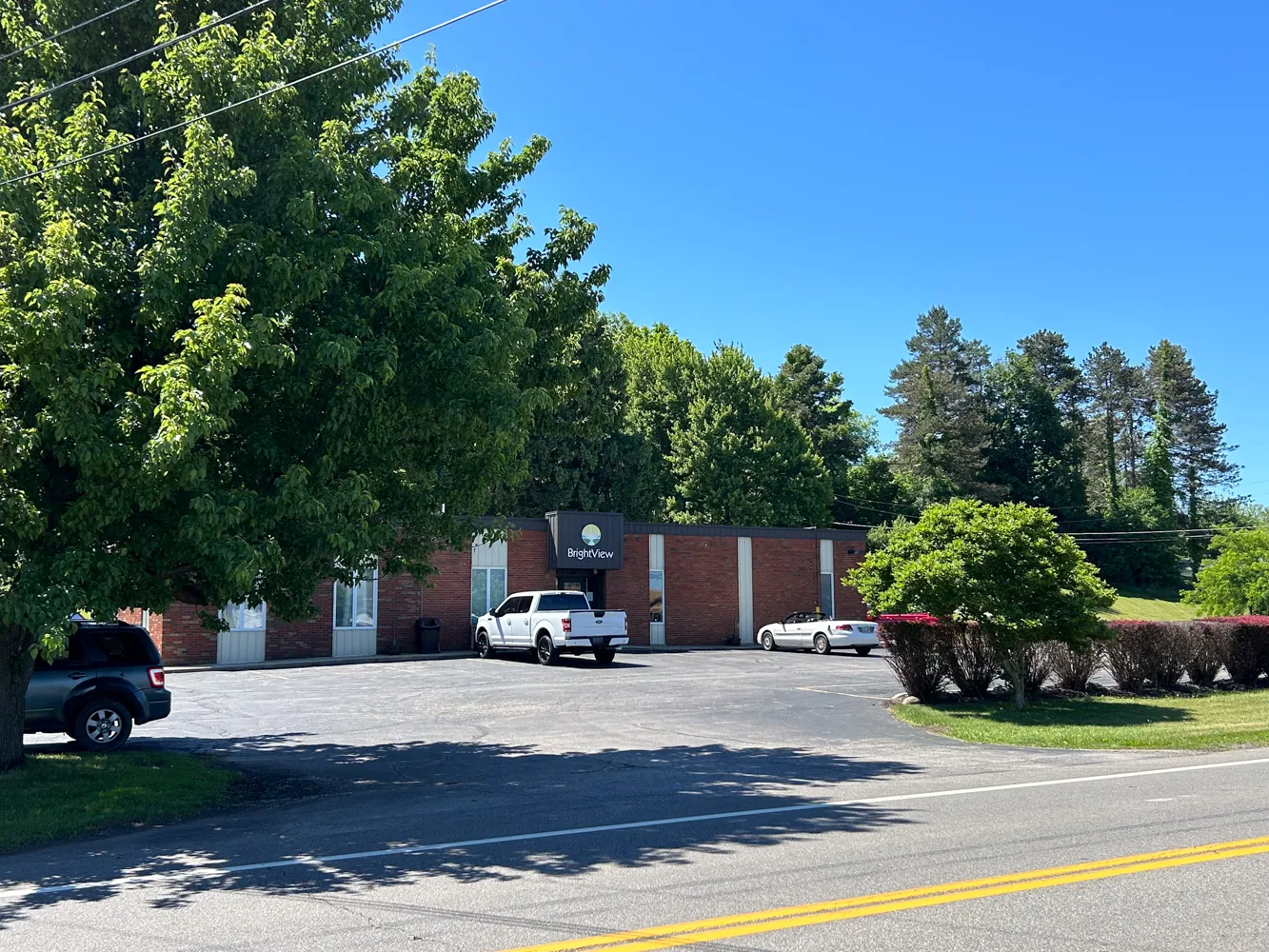 Wide view of BrightView Ashtabula addiction treatment center with brick exterior, parking lot, trees, and BrightView entrance signage
