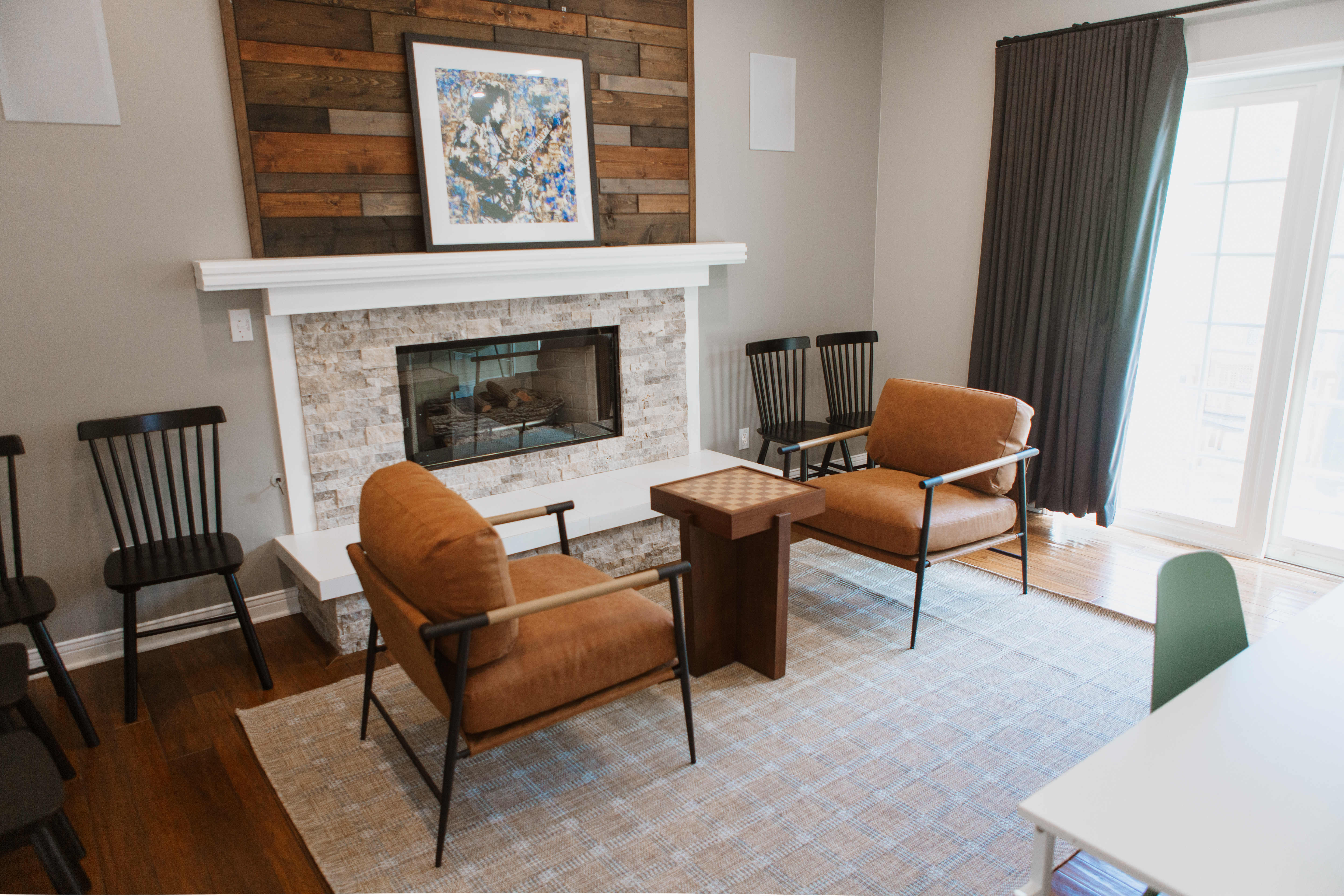 Fireplace with two brown chairs and small table