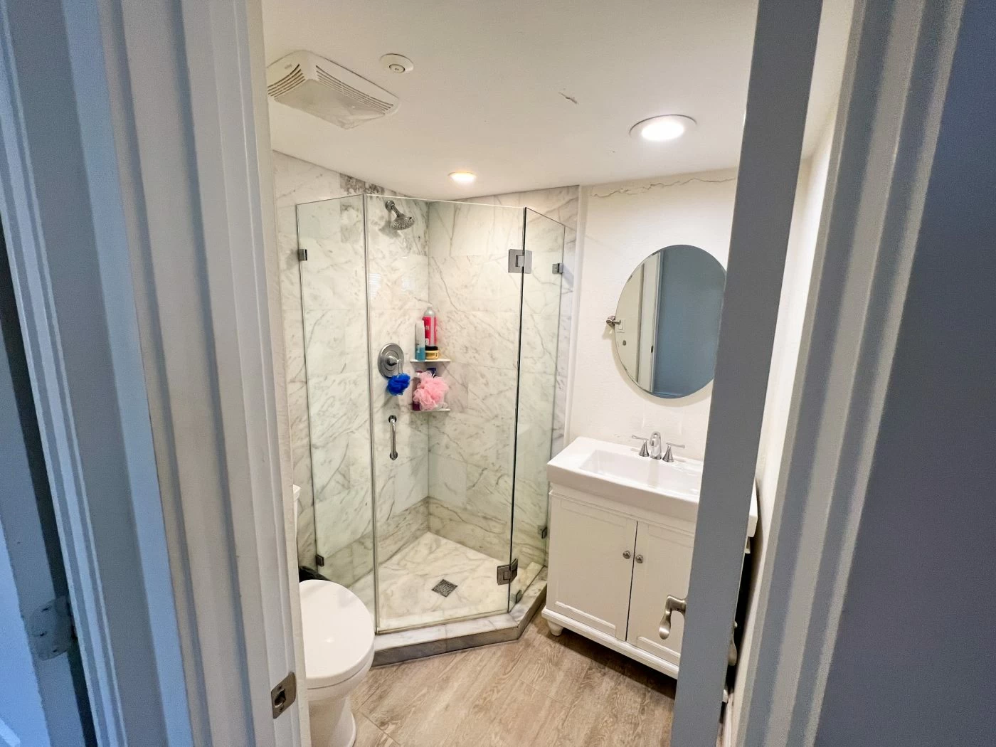 Modern bathroom with marble-style walk-in shower and vanity sink