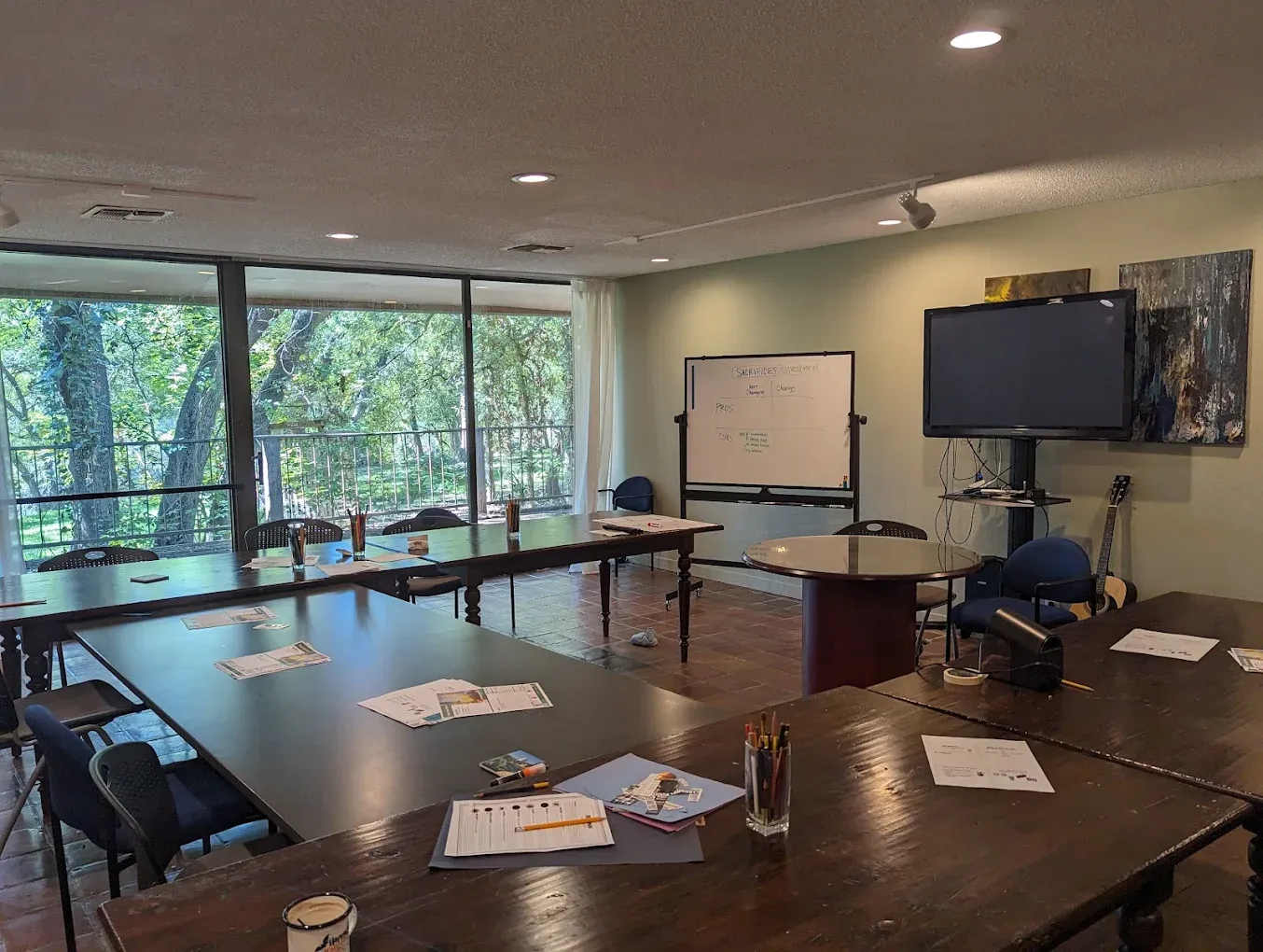 Group therapy room with tables, TV, and whiteboard