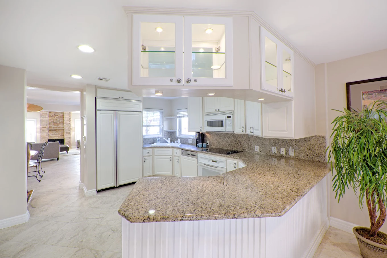 White kitchen with granite counters and built-in appliances