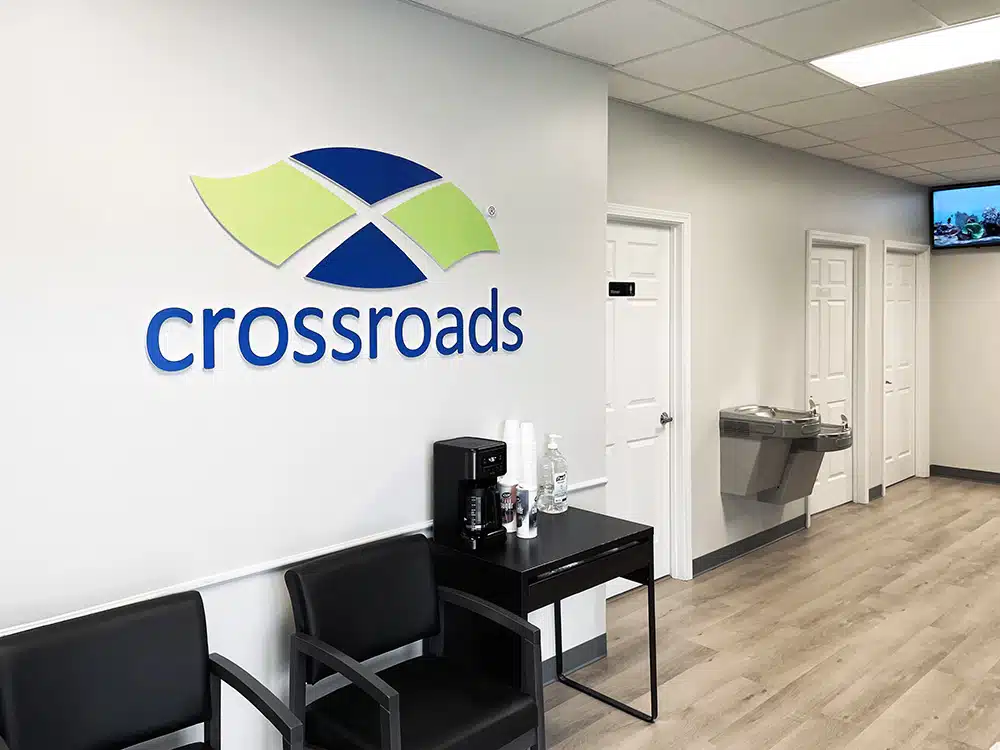 Waiting area with chairs, coffee station, and logo on wall