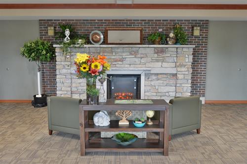 Stone fireplace with chairs and flower arrangement