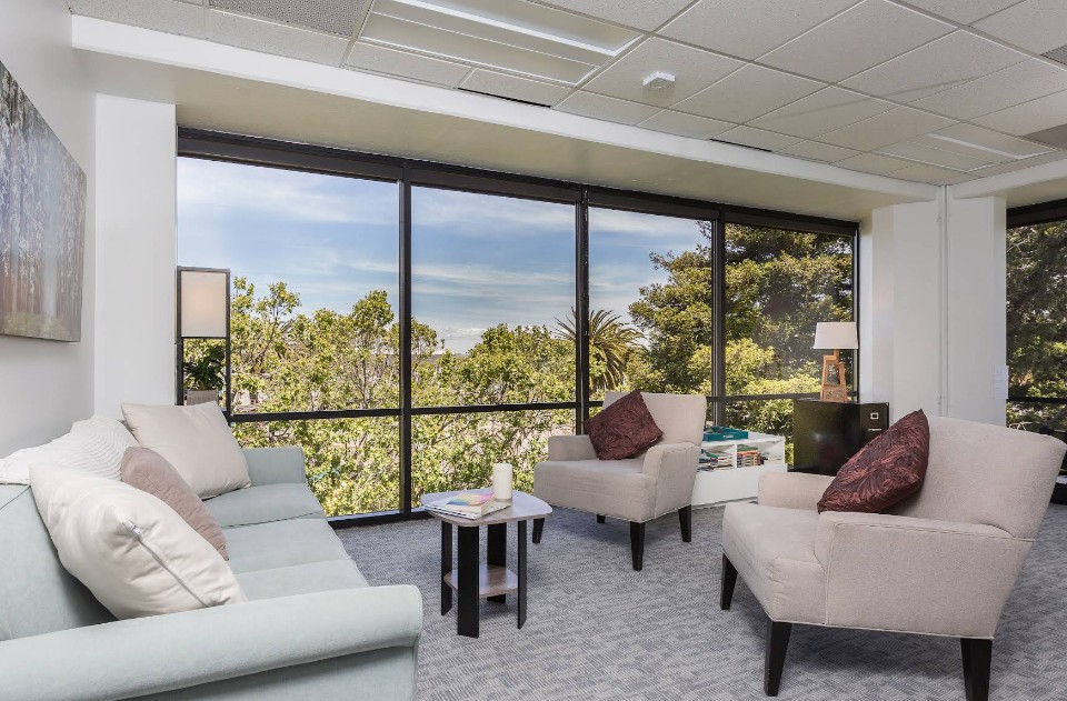 Therapy room with seating and floor-to-ceiling windows