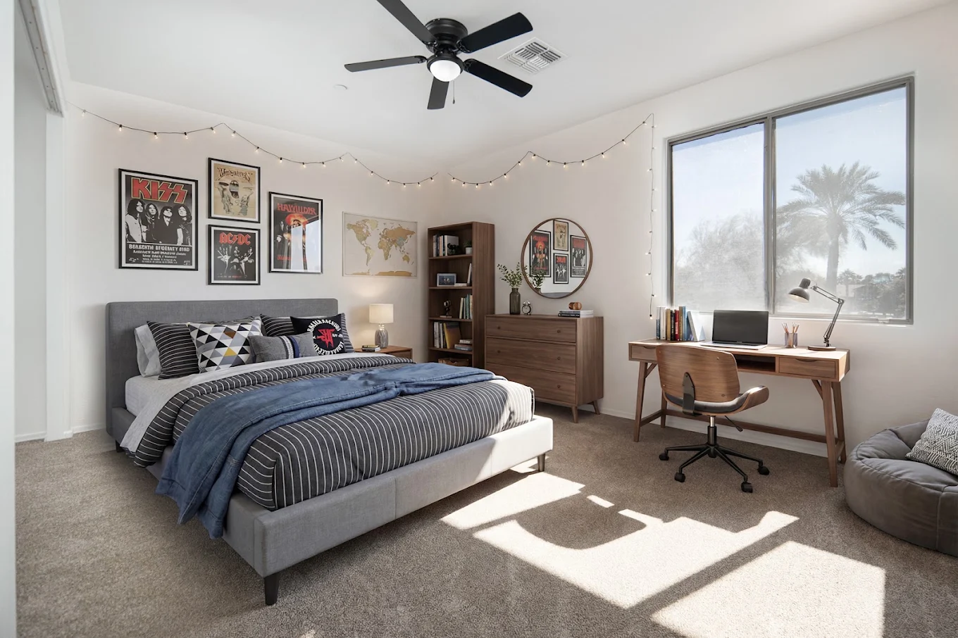 Bright furnished bedroom with bed, desk, storage, and large windows