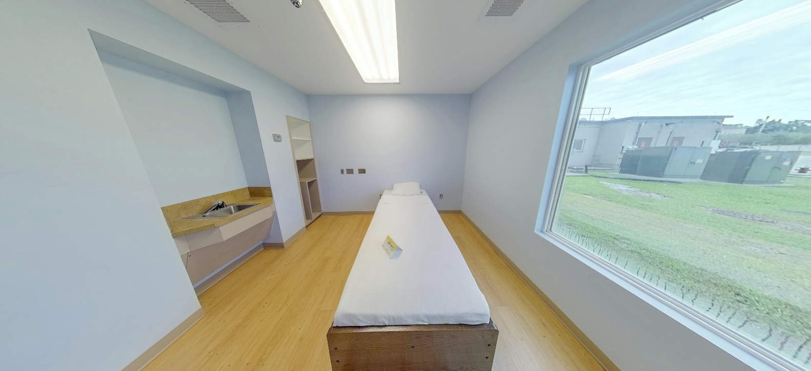 Private patient room with bed and large window